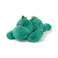Grünes liegendes Dinosaurier-Kuscheltier, glänzende Augen, Rückenkamm, auf weißem Hintergrund.