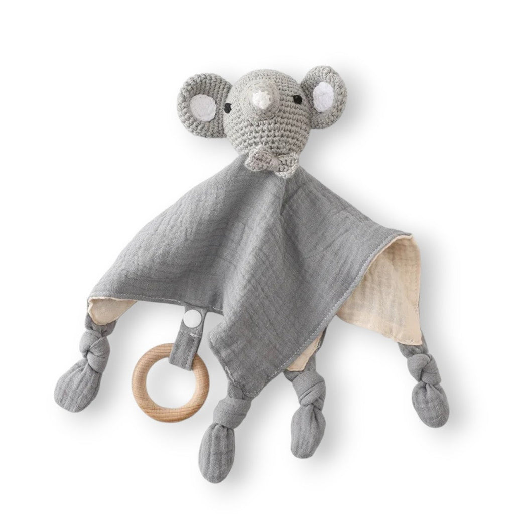 Flaches Häkel-Schmusetier Elefant, zweifarbiges Baumwoll-Schmusetuch grau mit beiger Unterseite, geknotete Enden, Ring aus Naturholz, weißer Hintergrund.