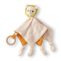 Flaches Häkel-Schmusetier Baby-Löwe, zweifarbiges Musselin-Schmusetuch beige und orange, geknotete Enden und Ring aus Naturholz, weißer Hintergrund.