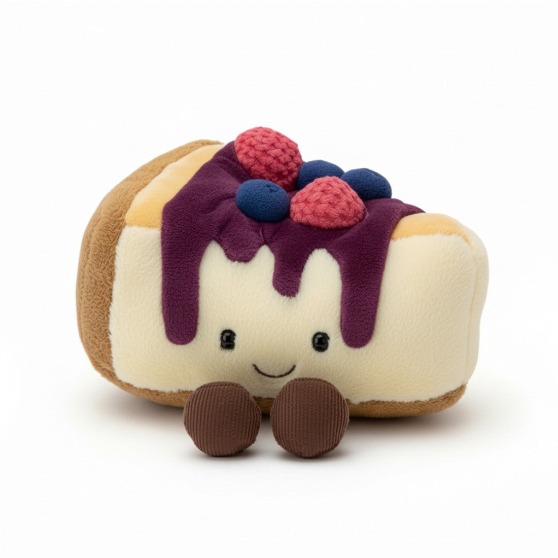 Kuscheltier in Form eines cremefarbenen Cheesecake-Kuchenstücks mit fließendem lila Sirup, kleinen blauen Heidelbeeren und rosa Himbeeren obenauf, lächelndes Gesicht mit großen runden Augen und geschwungenem Mund, zwei kleinen braunen Pfötchen darunter, auf weißem Hintergrund.
